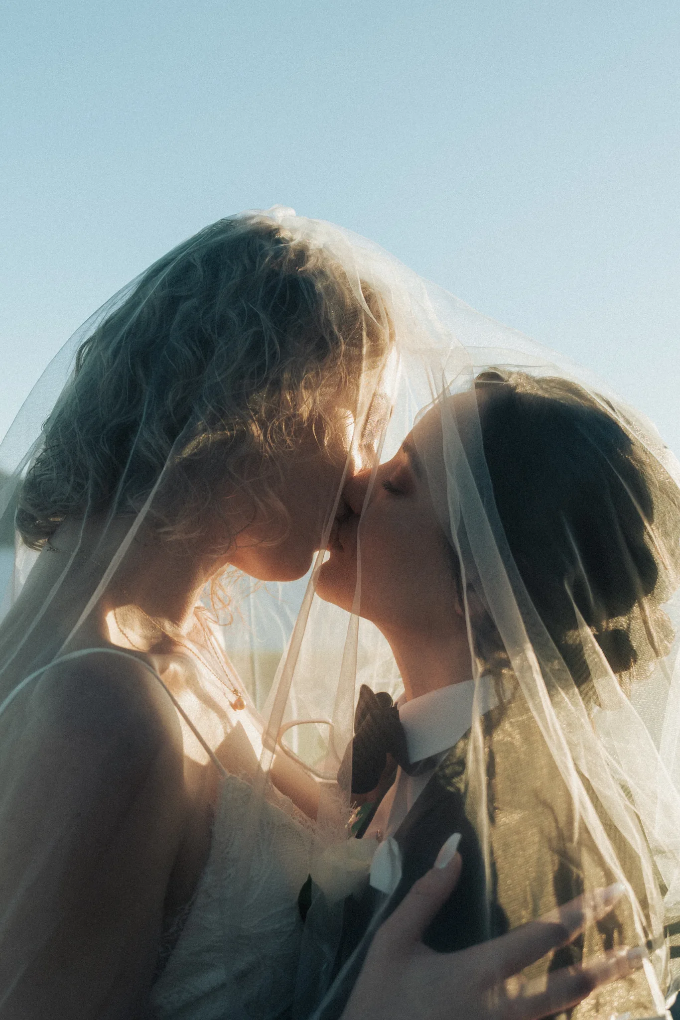 The bride beneath her veil, backlit by the afternoon sun